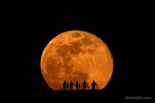 hình bóng của 4 nhạc sĩ với vầng trăng tròn khổng lồ màu cam phía sau