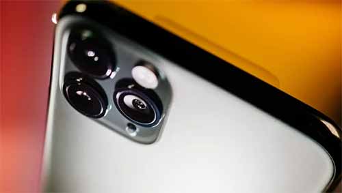 Cận cảnh chi tiết camera ba ống kính của điện thoại thông minh 11 Pro Max trên nền màu cam